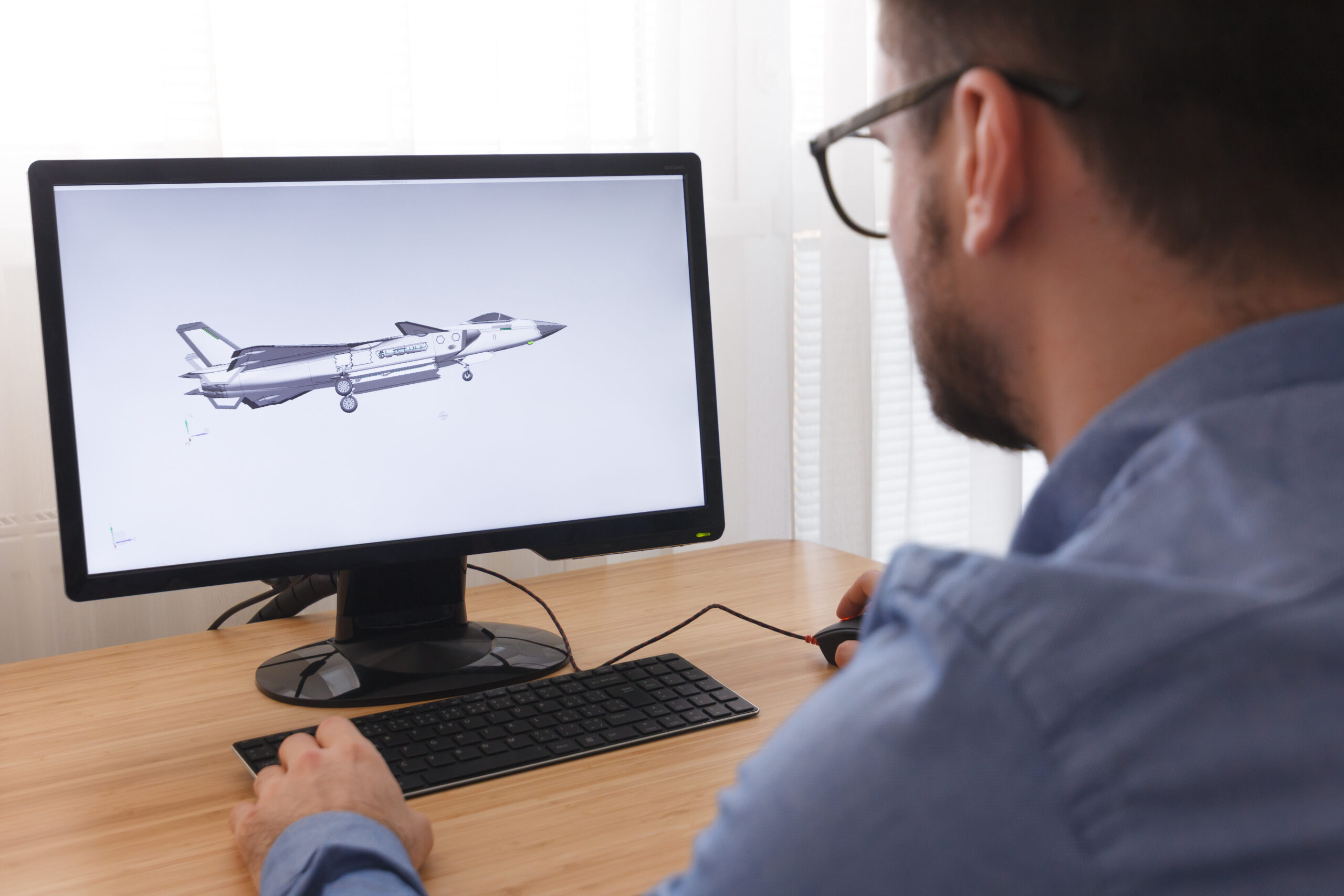 Engineer, Constructor, Designer in Glasses Working on a Personal Computer. He is Creating, Designing a New 3D Model of Aircraft, Airplane in CAD Program. Freelance Work, LOS ANGELES, CALIFORNIA - 25.10.2019.