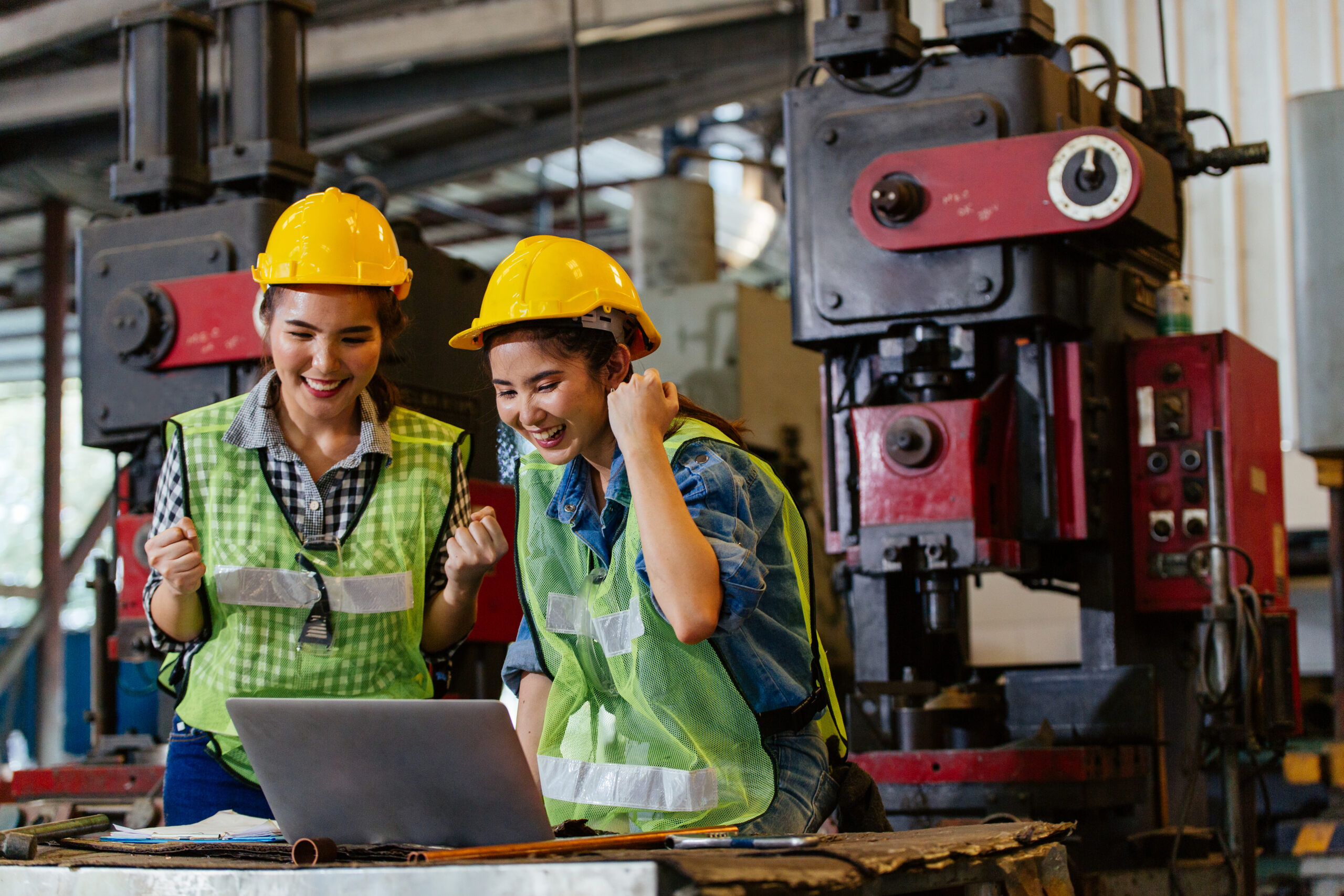 Happy successful female engineer workers celebrating for complete project at the construction factory.