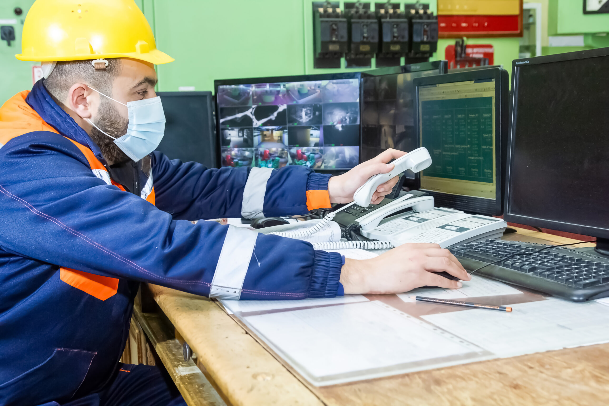 A male working with yellow helmet and protective mask