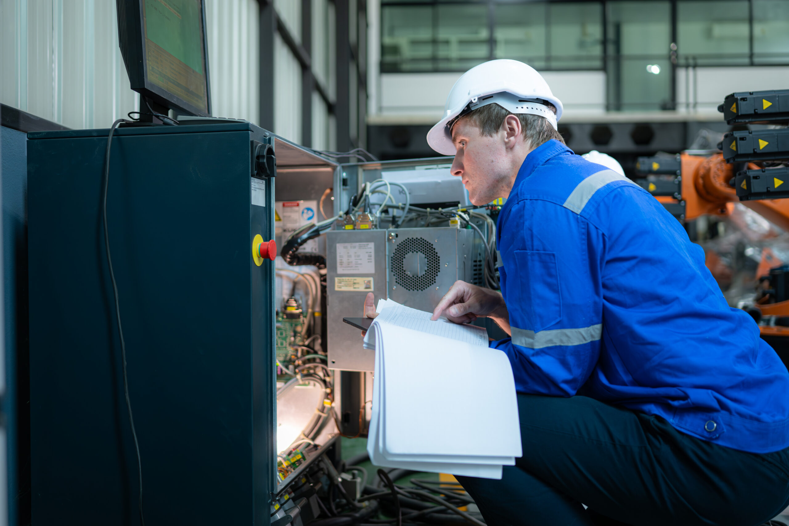 Technician working on the electrical control cabinet of robotic arm, Robotic arms industrial background