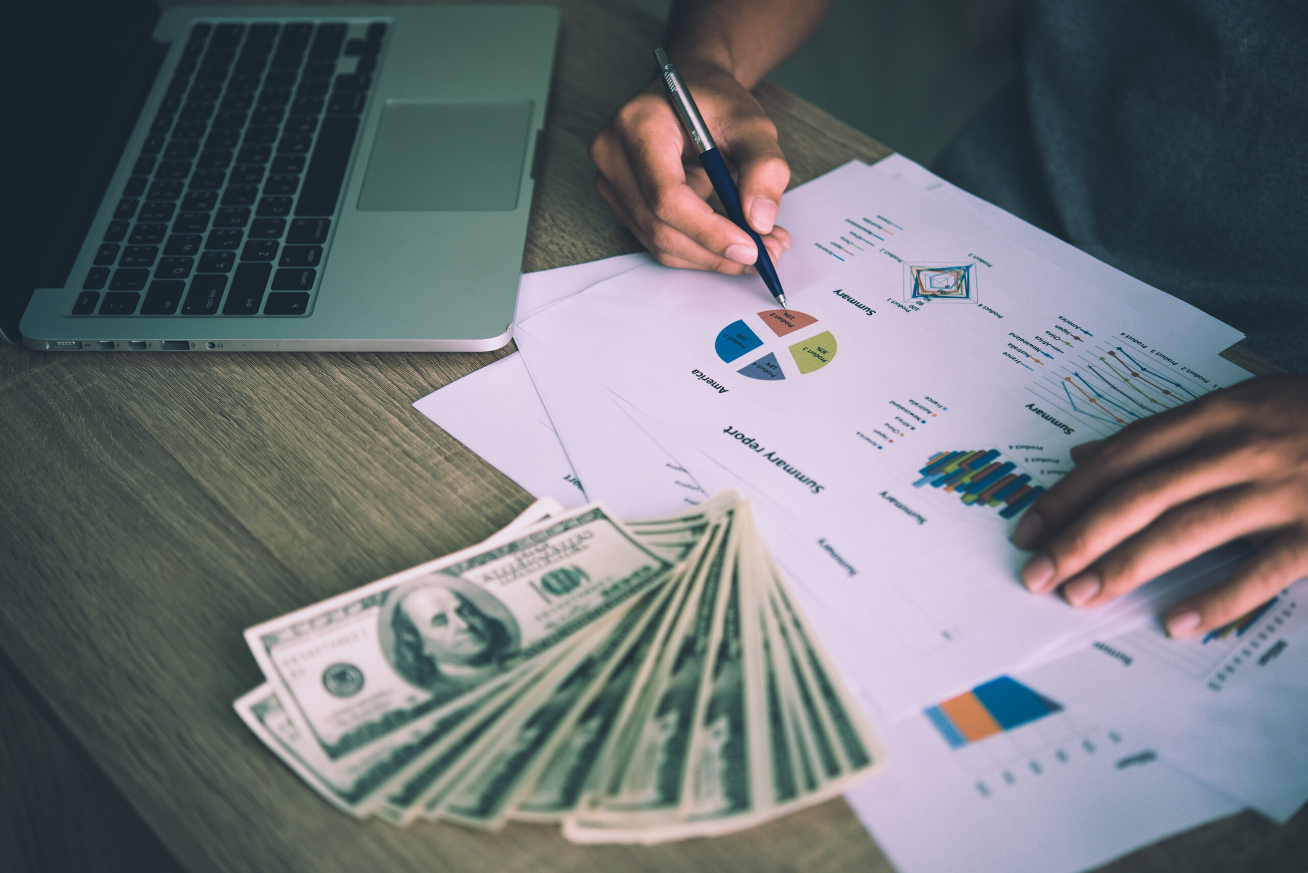 Working place of trader. The table covered by cash notes, keyboard and financial charts. Business financial working.