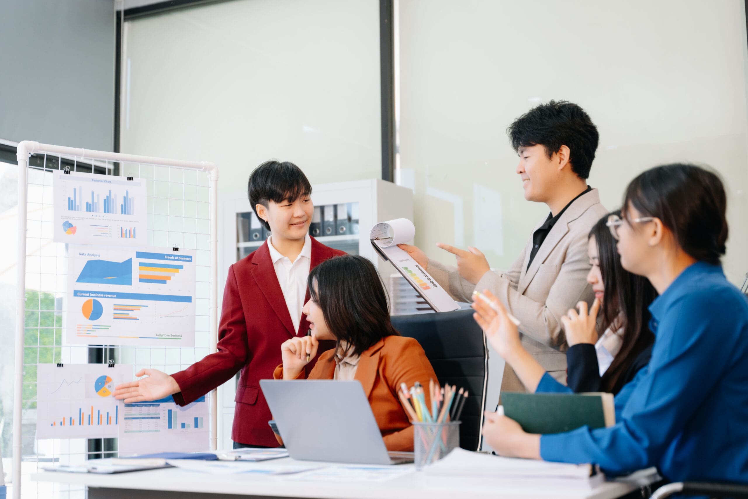 Happy businesspeople while collaborating on a new project in an office. Group of diverse businesspeople using a laptop and tablet in office.