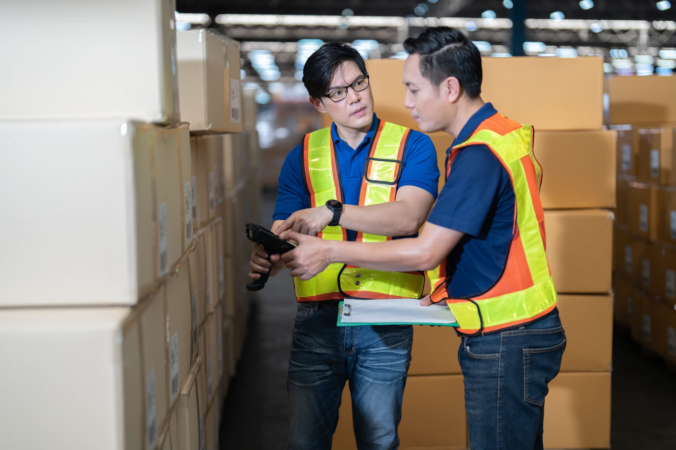 Manager and staff working in warehouse scan barcode looking check list for new arrived boxes
